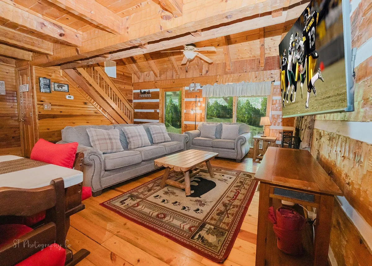 A warm and welcoming lounge area with plush sofa seating, a wooden coffee table, and a large television—the perfect spot for family gatherings, movie nights, or simply relaxing after an adventure in the mountains.