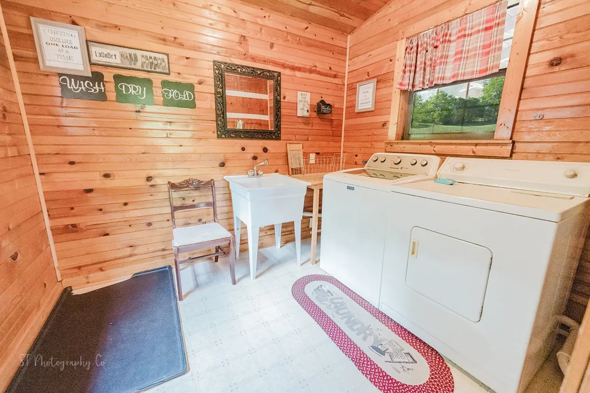 A view of the in-cabin laundry space, featuring a washing machine, drying rack, and comfortable seating with homey wall décor. This practical, inviting area ensures that adventure never has to pause for chores, keeping everyone comfortable and connected.